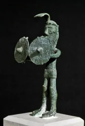Cultura nurágica (nuraghi) sarda: estatuilla que representa una criatura demoníaca armada con un doble escudo de bronce. Siglos VIII-VII a.C. Cagliari, Museo Nacional Arqueológico, Cerdeña, Italia