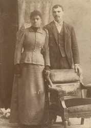 Fotografía de una pareja afroamericana de pie detrás de una silla, ca. 1890