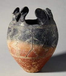 Cuenco de cerámica roja pulida, con cabeza de animal y discos solares, de Vounous, Chipre, Tumba 91, 2500-2075 a.C.