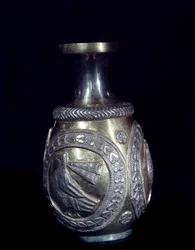 Artesanía sasánida: jarra de oro y plata decorada con tres medallones con gallos en relieve