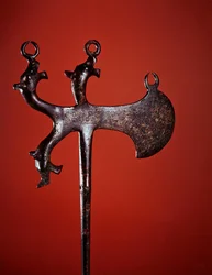 Alfiler en forma de hacha decorado con cabezas de animales (bronce)