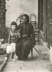 Guardia árabe (kawass otomano) con un niño en el jardín de una casa en el distrito de Judea de Jerusalén, 1867