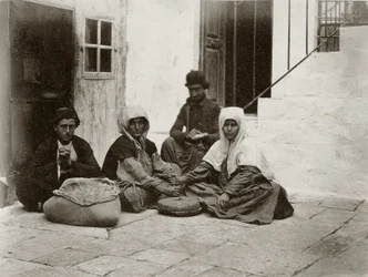 Mujeres moliendo harina con piedras de molino redondas en el patio de una casa en Jerusalén, 1867