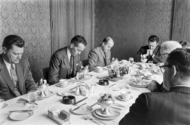 Empresarios rezando antes de empezar a comer en una reunión de recaudación de fondos de una iglesia