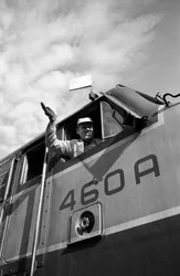 Un maquinista de la Great Northern Railroad saluda desde la cabina de una locomotora EMD E7