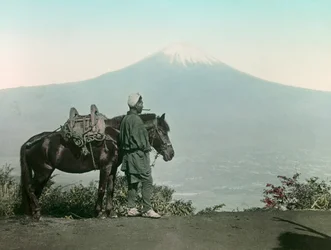 Hombre japonés con caballo en el monte Otome, toga contemplando el monte Fuji, circa 1900 - 1915 (fotografía)