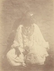 [Retrato de una mujer norteafricana sentada contra la pared].