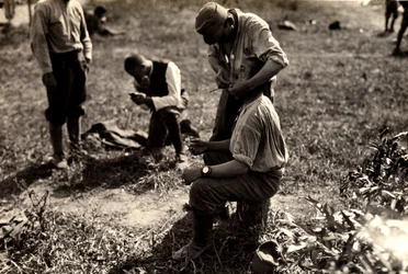 Prisioneros austriacos durante la Primera Guerra Mundial en Bagnaria Arsa, Udine, Italia; en primer plano un soldado afeita a un compañero, 02/04/1916 (foto b/n)