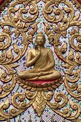 20151102, Vang Vieng, Laos: puerta de entrada ornamentada con relieves dorados. El Buda docente representa un momento particular de la vida de Buda, concretamente el primer sermón que pronunció después de alcanzar la iluminación