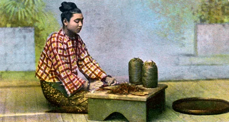 Una mujer birmana haciendo cigarros, c1900s