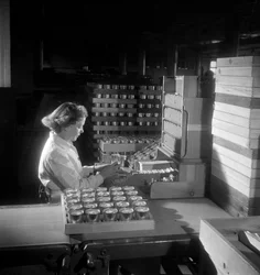 Una trabajadora empaca latas de cigarrillos, Londres 1950
