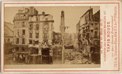 Comuna de París (1871): apertura de los grandes almacenes del Carpet Rouge, una tarjeta publicitaria que muestra el edificio un año antes, en ruinas durante la Comuna.