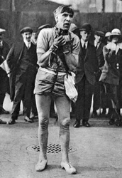 Un escapista entretiene a los espectadores en la cola para el patio de butacas, Londres, 1926-1927