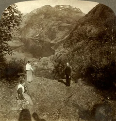 Heno en la repisa de la montaña sobre el pueblo de Marok y el espejo claro del fiordo de Geiranger, Noruega