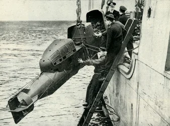 Izando un torpedo tripulado Chariot a bordo de un barco, Segunda Guerra Mundial, 1945
