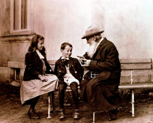 León Tolstói, escritor, filósofo y místico ruso, contando una historia a sus nietos, c1890-1910