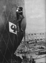 Haciendo ajustes a la red de un globo antes de unir la cesta, c1935 c1937