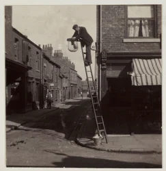 Hombre limpiando una farola de gas, c 1905