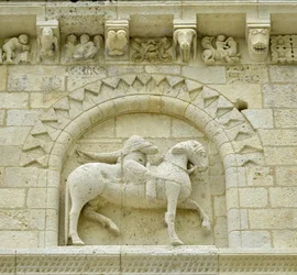 Arte románico: detalle de la fachada que representa a Hugues de Surgeres y Geoffroy de Vendome o al emperador Constantino I el Grande cuyo pie del caballo pisaría la herejía y Cristo triunfante del mal y la muerte, Notre Dame de Surgeres