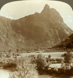 Picos afilados de Romdalshorn coronando la pared de la montaña sobre el río Rauma, Noruega, c. 1905