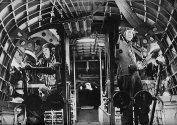 Los artilleros de mitad del barco de un hidroavión de la RAF alertas en sus estaciones, c1940