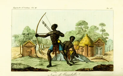 Dos hombres de Luanda de Cancobella, Angola, con arcos y flechas, frente a viviendas, chozas, altares sagrados, etc.