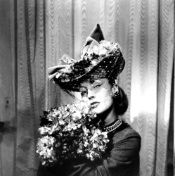 Mujer con sombrero con velo, sosteniendo un ramo de flores, París, 1943