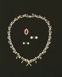 Collar de diseño de pergamino y hojas Art Deco; anillo de racimo de rubíes y diamantes; anillo de tres piedras con zafiro y diamantes; anillo de tres piedras con esmeralda y diamantes