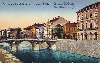 Postal que representa Sarajevo, el muelle Appel y el Puente Latino, lugar del asesinato del archiduque Francisco Fernando y de su esposa Sofía el 28 de junio de 1914, hacia 1920