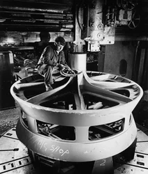 Un ajustador en la parte superior de un gran objeto fundido usa una máquina de mandrinado vertical