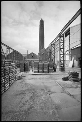 Vista general de la torre de tiro de Elswick, demolida en 1968-69, utilizada para crear tiros de plomo, con un patio con paletas en primer plano, c.1955-69 (foto b/n).