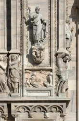 Arquitectura: estatua de San Lucas (1811), y bajo relieve que representa la aparición del ángel a la madre de Sansón (1659). (detalle) de la fachada de la Catedral (dome o duomo) de Milán, Italia