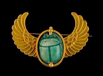 Escarabajo de esteatita azul vidriada montado en un alfiler alado de oro