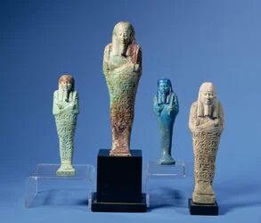 Cuatro figuras de Shabti esmaltadas en verde o azul, tres con bandas horizontales de inscripción jeroglífica, egipcias, que datan del siglo VII al III a.C.
