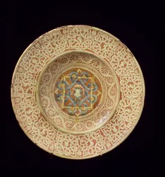 Plato de Maiolica Decorado con un Elaborado Diseño de Nudo Repetitivo enmarcando Cabezas de Perfil en el Borde y un Escudo en la Placa Central, Italiano, Hecho en Toscana