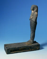 Figura de Ptah-Sokar-Osiris con peluca tripartita y brazos cruzados sobre un pedestal rectangular con un compartimento que contiene una sección de papiro, egipcio, Dinastía 21-22, c.900 a.C.