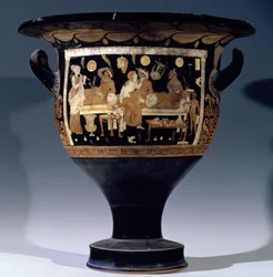 Crátera de campana de figuras rojas que representa una escena de banquete