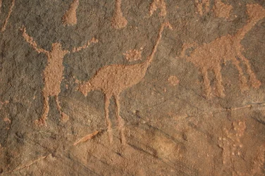 Arte rupestre, Prehistoria: Grabado de un personaje y avestruces en el macizo de Uweinat, Sudán (Karkur-Talh o Karkur Talh). Período de 8000 a 3000 años a.C. Fotografía