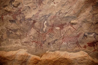 Arte rupestre, Prehistoria: Pintura rupestre de un grupo de ganado y personajes policromos en un refugio ornamentado, en el macizo de Uweinat, Sudán. Período de 8000 a 3000 años a.C. Fotografía
