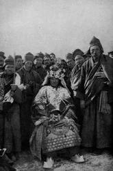 Tíbet. Mago con vestimenta completa y una banda de monjes admiradores. 1920
