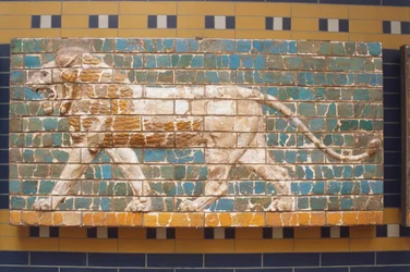 Asia, Turquía, Estambul, relieve de león pintado en pared de ladrillo, vista lateral de un feroz león amarillo con gran melena caminando contra un fondo verde
