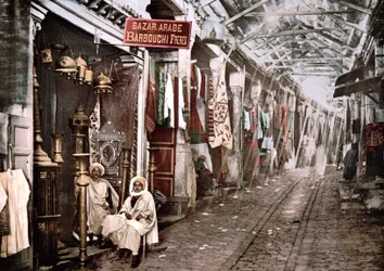 Le souc el Trouck en Túnez: tienda con letrero en francés “Bazar árabe Hermanos Barbouchi”. Foto cromo ca. 1900