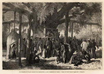 Los anamitas de la escolta de Garnier dan una representación improvisada a sus compatriotas en Lakon (Laos), después de haber montado un pequeño teatro de marionetas al pie de un baniano con un enorme tronco. Grabado para ilustrar el viaje de exploración e