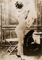 Retrato de cuerpo entero de una joven desnuda vistiéndose.