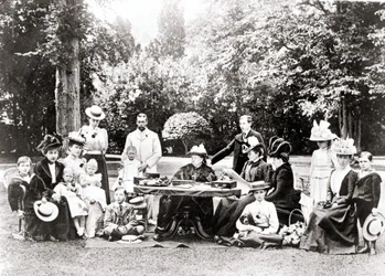 Miembros de la Familia Real Británica, incluyendo al Rey Jorge V, el Rey Eduardo VIII alrededor de la Reina Victoria en una fiesta en el jardín. Fotografía entre 1895 y 1901