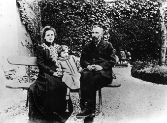 Pierre (1859-1906) y Marie Curie (1867-1934) sentados en un banco en un jardín