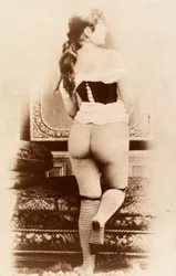Retrato de una mujer joven, parcialmente desnuda, vista de espaldas.