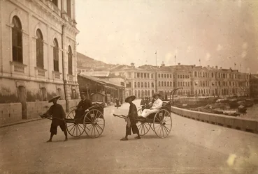 Dos hombres transportados en rickshaw en Hong Kong.
