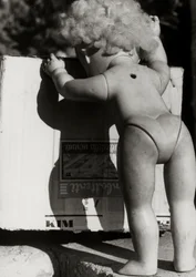 Muñeca abandonada junto a una caja