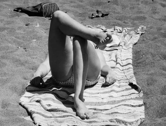 Piernas femeninas en una playa, c.1960 (foto b/n)